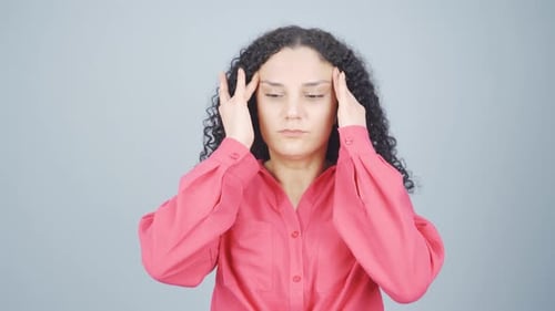 Woman Massaging Temples in Studio Close Up