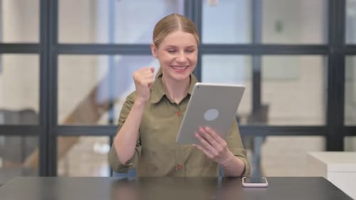 Mature Adult Woman Celebrating Online Success on Digital Tablet