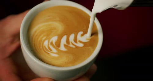 Macro of a barman while drawing with the froth the cappuccino in a typical italian bar. Concept: C
