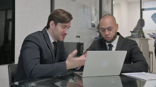 Angry Businessman Talking with Male Worker in Office