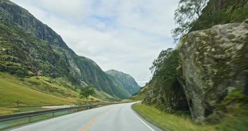 Driving on Scenic Road Through Norway Mountain Valley Landscape