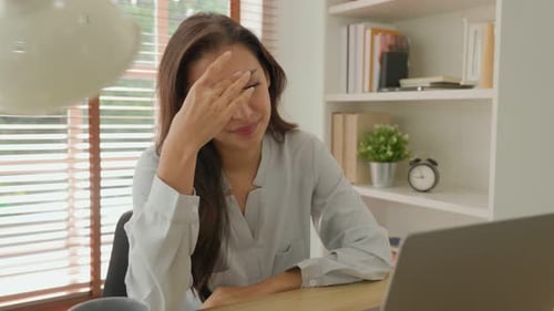 Die kaukasische Frau hat Kopfschmerzen, wenn sie zu lange an ihrem Laptop arbeitet.