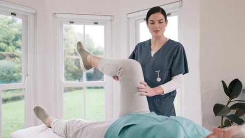 Physiotherapist Assists Patient with Leg Exercises