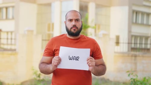 Bald indian Man Holding War Poster