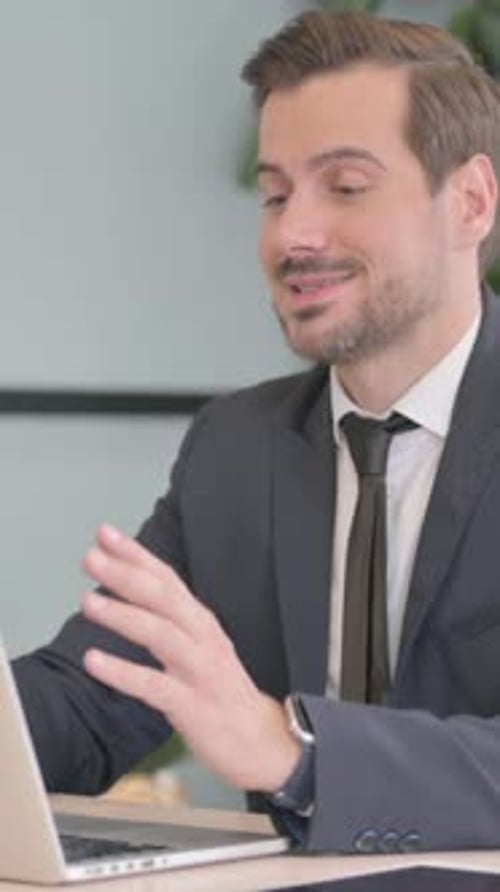 Smiling Businessman having a Video Conference on Laptop