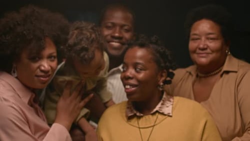Happy family smiling indoors with dark background