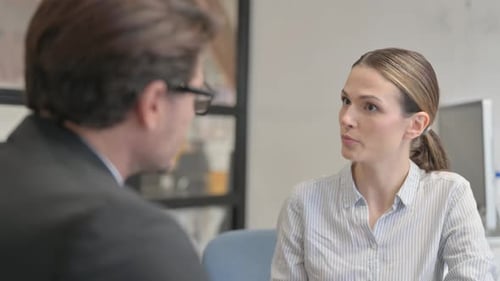 Woman Discusses Business with Colleague in Bright Office