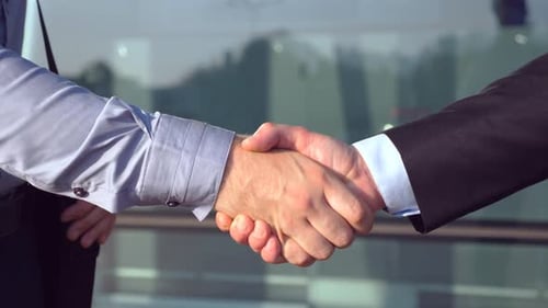 Close Up of Successful Businessmen Greeting Each Other Near Office Building