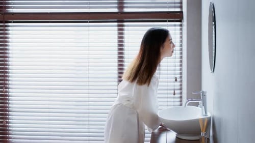 Woman in Robe Applying Under Eye Patches