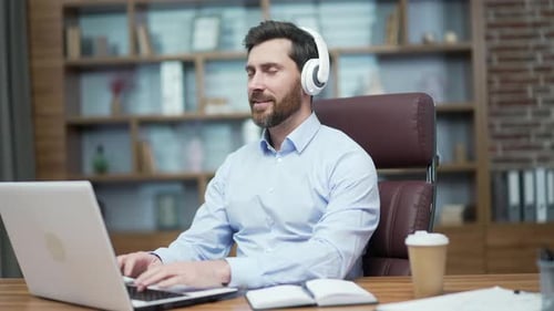 Relaxed Man Working With Headphones in Office Setting