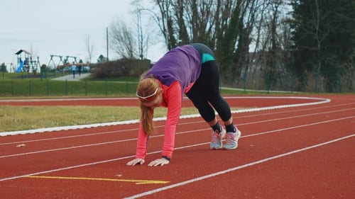 Woman Stretching and Preparing to Run on Track