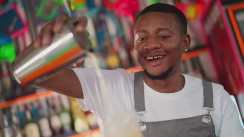 Bartender Pouring Cocktail in Bar Setting