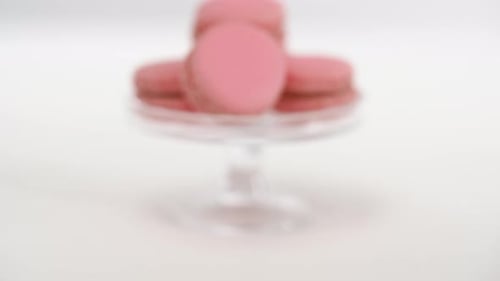 Sweets, Pastry and Food Concept - Pink Macarons on Glass Confectionery Stand