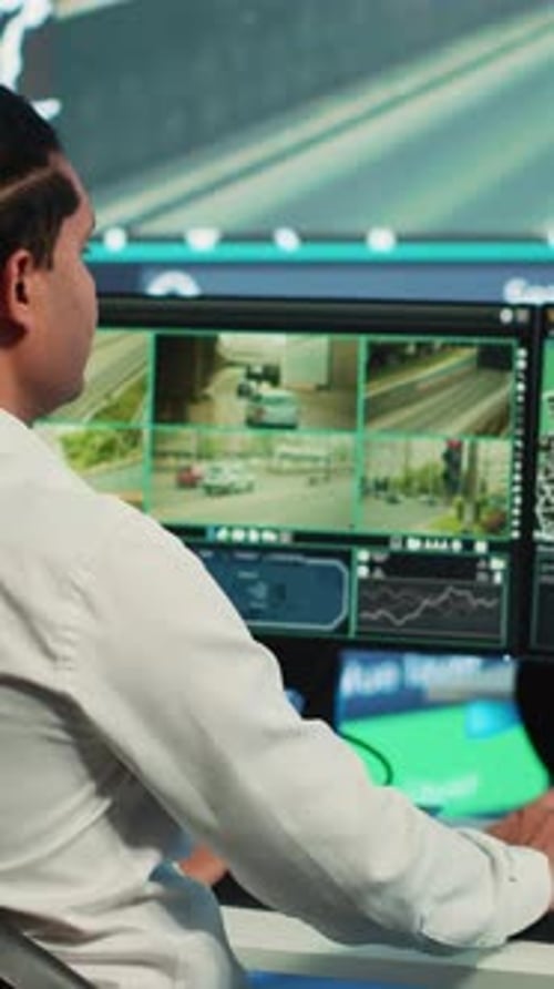 Man Monitors Traffic Cameras in a Control Center