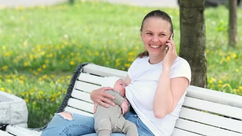 Mother Breastfeeding Baby in Her Arms in Summer Park Beautiful Mom Breast Feeding Her Toddler Child