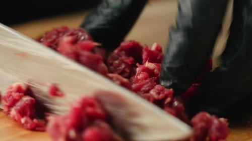 Chopping Red Meat With Knife on Cutting Board