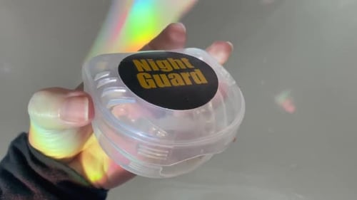 Hand Holding Dental Night Guard Appliance in Case