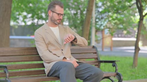 Bearded Man Checking Watch While Sitting on Bench