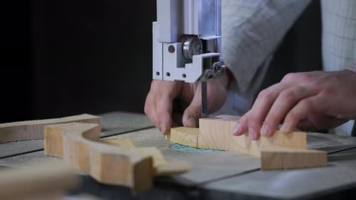 A man works with wood in a workshop. Working with wooden blanks. A man drills holes in wooden blanks
