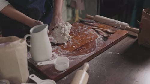 Woman Kneading Dough on Wooden Cutting Board