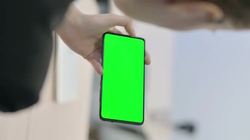 Vertical Video of Businesswoman Holding Horizontal Smartphone with Green Screen