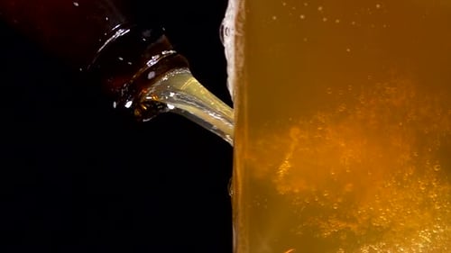 Beer Pouring From Brown Bottle Into Glass