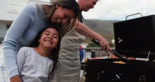 Family grilling food on a barbecue outdoors