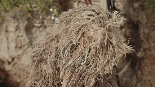 Camouflaged Soldier with Rifle Aiming Outdoors