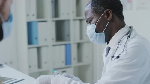 Doctor Preparing Injection for Patient in Clinic