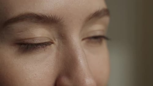 Nahaufnahme der Augen und der Nase einer jungen Frau in sanftem Innenlicht