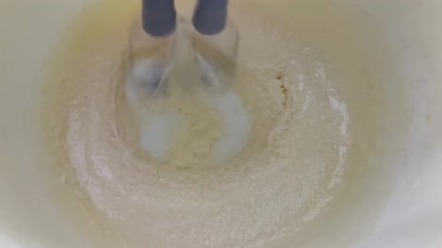 Electric Mixer Blending Pale Batter in Bowl