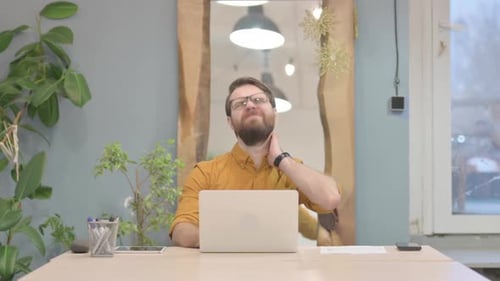 Man Working at Desk With Neck Pain