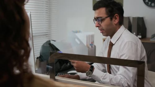 Close-up of Unrecognizable Woman Passing Papers to Bank Assistant