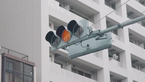Ampeln auf der Straße, Blinker von grün auf rot mit einem Komplex im Hintergrund