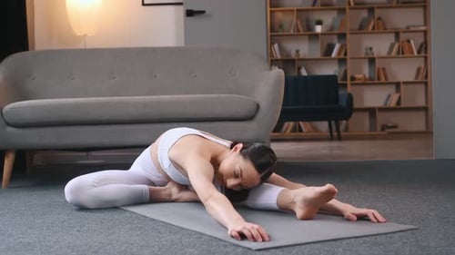 Woman Stretching on Yoga Mat in Living Room