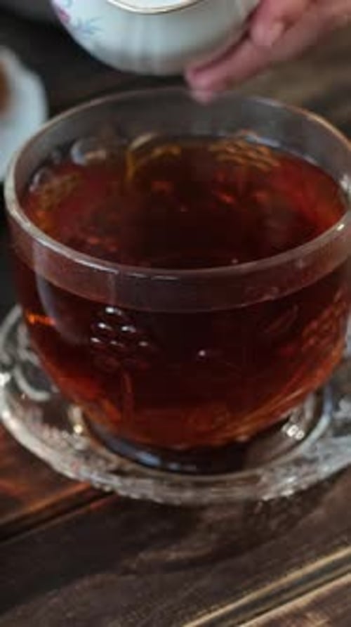 Vídeo vertical: Desayuno inglés vertiendo leche en una taza de té