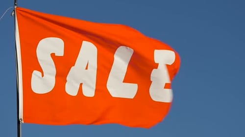 Bright Orange Sale Banner Waving Against Blue Sky