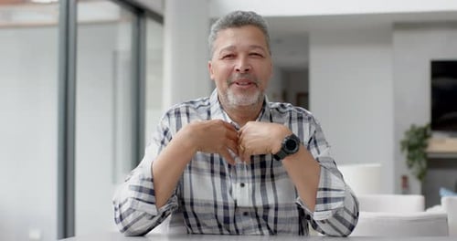 Middle-Aged Man Talking At Table Indoors