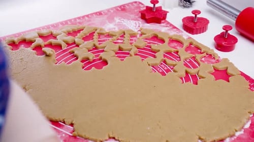 Person Cuts Christmas Cookies from Dough with Cookie Cutters