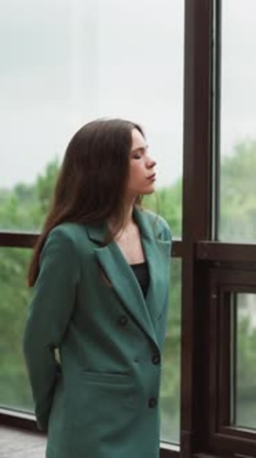 Woman in Green Blazer Looks Out Window