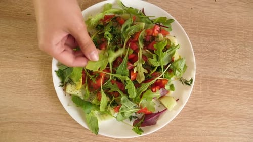 58. Greens are added to a vegetable salad of cucumbers and tomatoes.