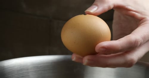 Breaking Egg into Bowl for Cooking Preparation