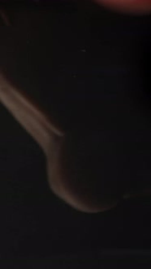 Fingerprinting against a black background, close-up shot. Vertical video.