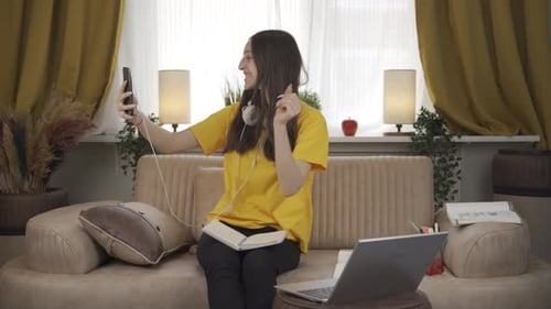 Female student using phone while dancing.