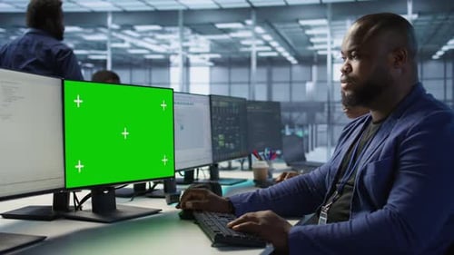 Mann arbeitet in einer Serverfarm mit Greenscreen-Computer