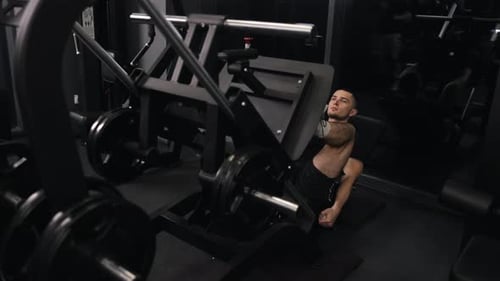 Man Leg Pressing Weights at the Gym