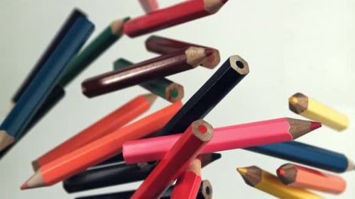 Multicolored Pencils Fly Up and Fall on a White Background Filmed on a Highspeed Camera at 1000 Fps