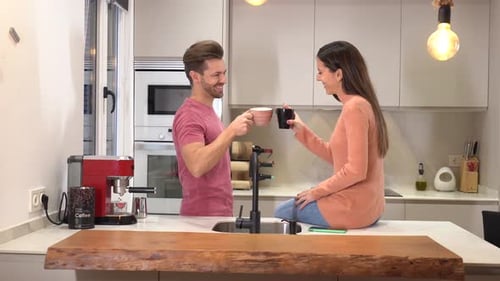 Couple Toasting Coffee in Modern Kitchen