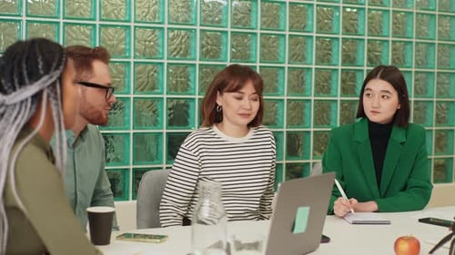 Team Discussing Business Around Table in Office