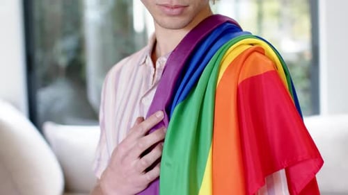 Young Adult Smiling with Pride Flag Indoors